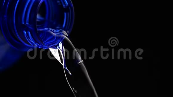 蓝色瓶子中的水在黑色背景下缓慢流动视频的预览图