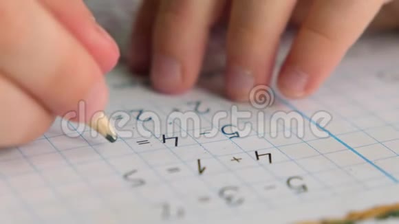 学龄前男孩蹒跚学步拿着铅笔在桌子上写字或做数学作业双手合拢视频的预览图