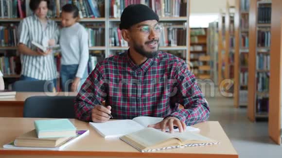 非裔美国人在图书馆学习坐在书桌上读写视频的预览图
