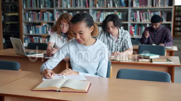 非裔美国女孩在图书馆读书从男学生那里拿书视频的预览图