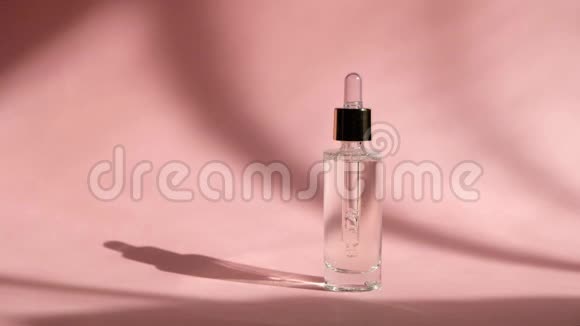 将血清滴在粉红色背景的透明玻璃瓶中并女士的手护肤美容美容精华视频的预览图