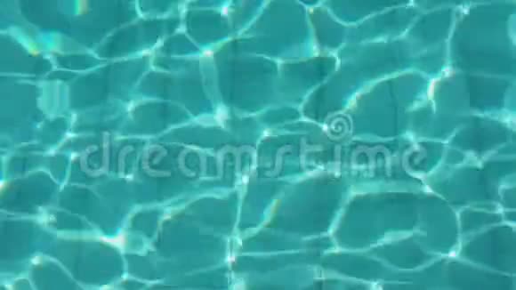 在阳光明媚的日子里游泳池里有纯蓝色的水光线反射空中镜头4K视频的预览图