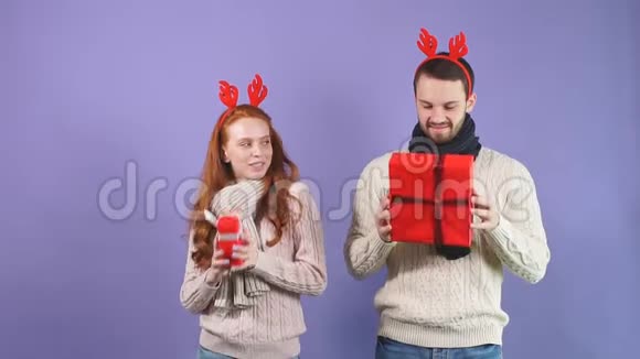 一对美丽的爱侣在工作室里拿着各种各样的圣诞礼物背景是黑色视频的预览图