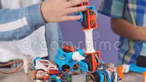 白种人儿童组装机器人的特写肖像这些机器人被隔离在紫色背景上视频的预览图