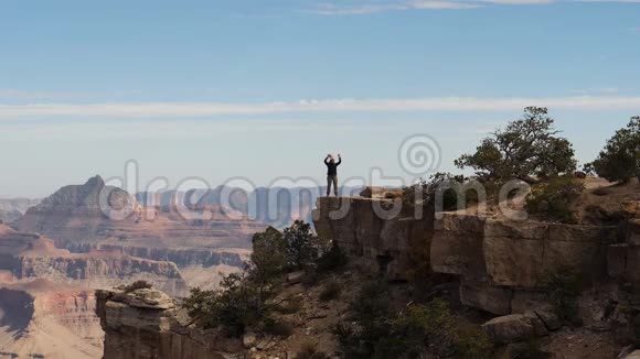 Hiker女士站在大峡谷公园悬崖边上举起双手视频的预览图