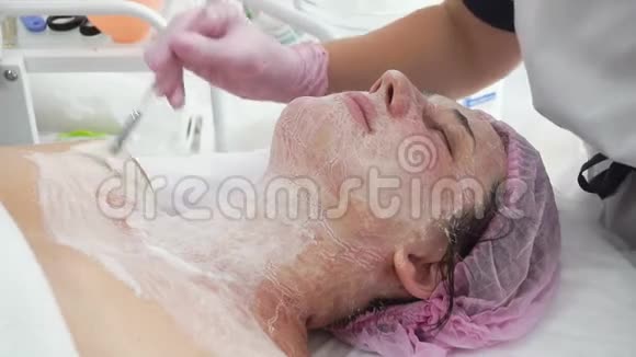 美容师在成年女性脸上戴护理面具视频的预览图