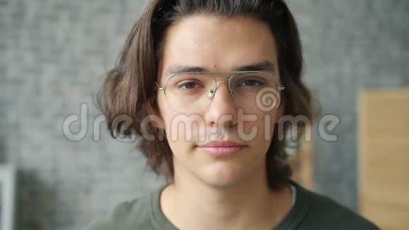一位戴眼镜独自看相机的帅哥的特写镜头视频的预览图