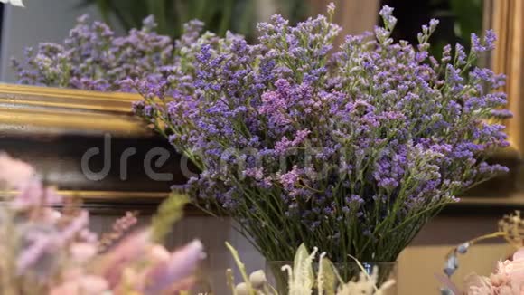 用紫色的格子花和桉树在花束中干燥的花花店装饰装修视频的预览图