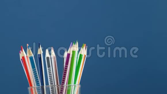 彩色铅笔在玻璃中旋转蓝色背景回到学校的概念视频的预览图