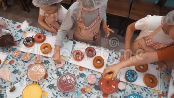 俯瞰着孩子们品尝美味的甜圈视频的预览图