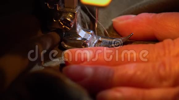 在现代缝纫机上修理土黄色衣服的过程视频的预览图
