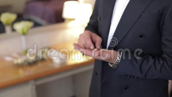 英俊的新郎手里拿着结婚戒指结婚的早晨商人视频的预览图