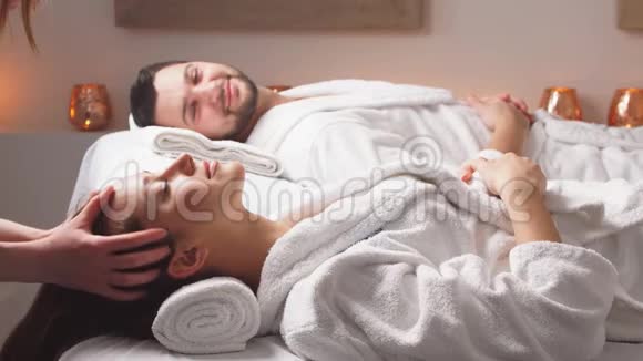 迷人的情侣躺在豪华水疗中心的按摩床上视频的预览图