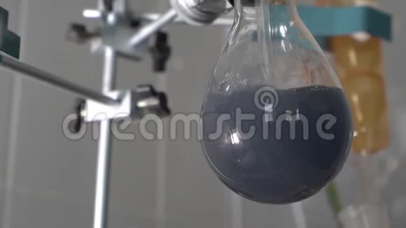 在实验室的研究过程中在玻璃试管中煮沸灰色液体特写视频的预览图