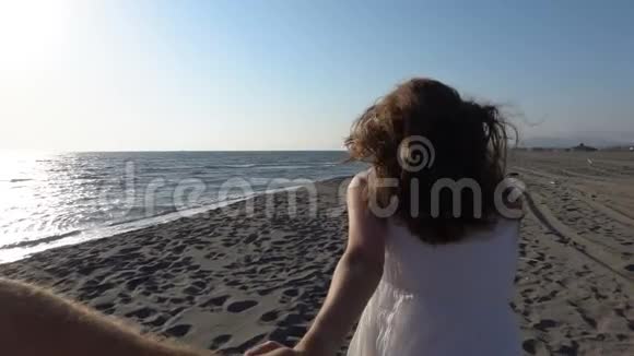 女孩沿着海滩奔跑拉着一个男人手第一人称视角视频的预览图