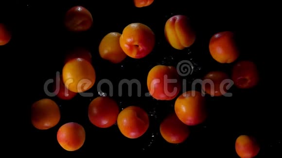 美味的杏子在黑色背景上溅起水花飞上天空视频的预览图