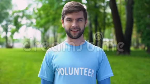 快乐的男性活动家指着蓝色t恤上的志愿者词生态项目视频的预览图