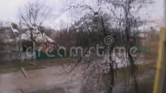 刮风的街道上的雨天玻璃窗上的水滴视频的预览图
