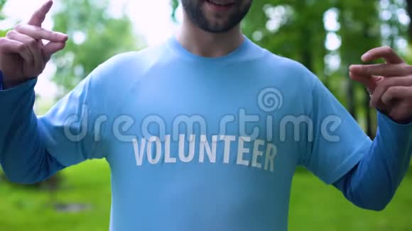 微笑的人指着t恤上的志愿者单词野生动物保护地球视频的预览图