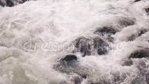 关闭泡沫瀑布水溅在岩石上视频的预览图