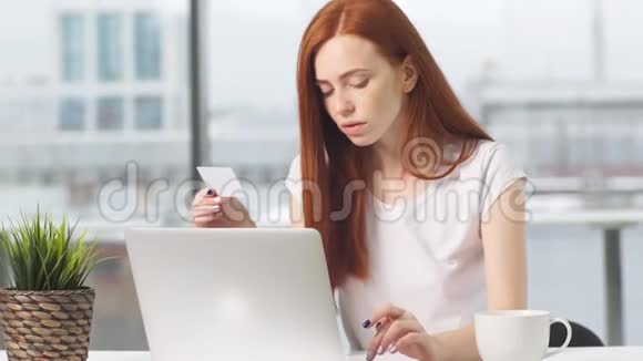 年轻女孩在网上购物用信用卡支付视频的预览图