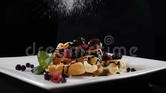 糖粉被倒入华夫饼在黑色背景上缓慢运动美味的甜点概念全高清视频的预览图