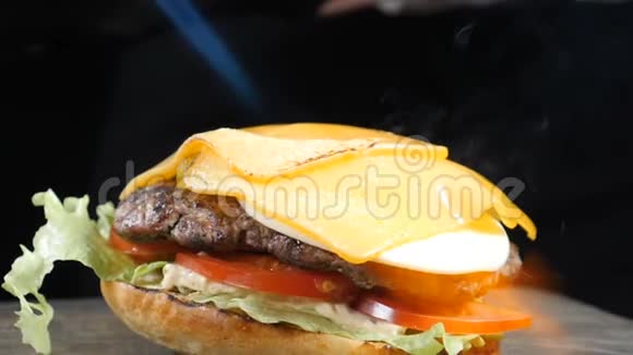 用吹火把把奶酪融化在汉堡肉切块上慢动作食物视频汉堡餐厅菜单烹饪视频的预览图
