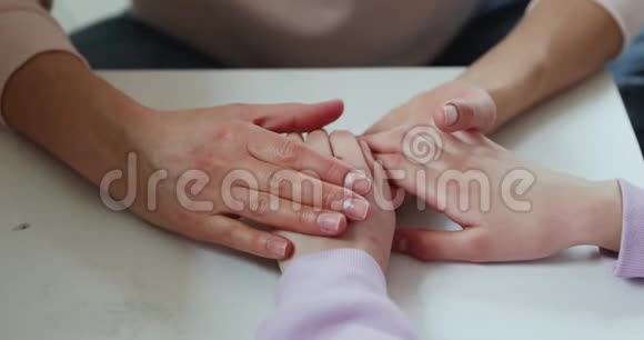 慈爱的母亲牵着女儿抚摸的手紧紧地视频的预览图