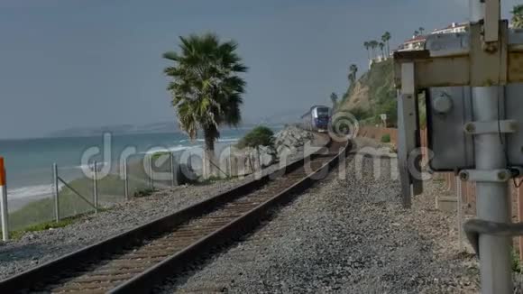 加州海岸铁路在圣克莱门特靠近太平洋冲浪飞机的棕榈之间行驶视频的预览图
