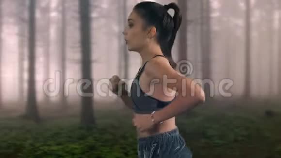 年轻的健身女运动员正在森林里跑步视频的预览图