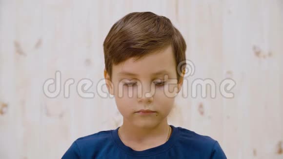 可爱的沉思男孩低头眨眼的肖像视频的预览图