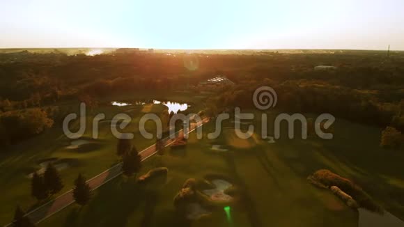 在有池塘的绿色高尔夫球场上空飞行视频的预览图