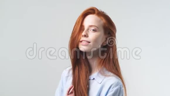 年轻漂亮的红发女孩在白色背景上的肖像微笑着跳舞摆姿势拍照视频的预览图