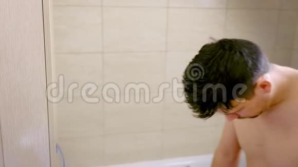 睡懒觉的年轻人清晨站在浴室里的肖像视频的预览图