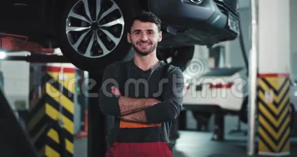 在一个现代的汽车服务中一个穿着制服的有吸引力的机械师在镜头前微笑着大而大就像视频的预览图