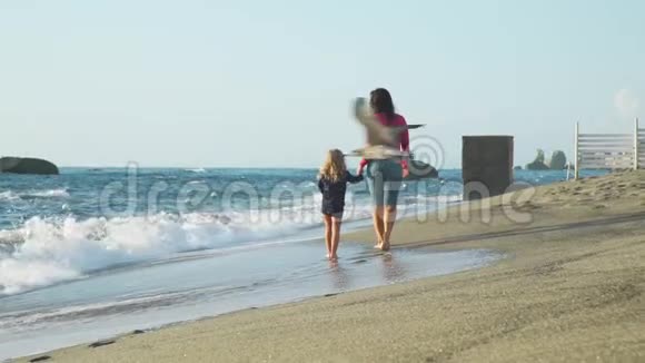 小女孩和妈妈在沙滩上散步视频的预览图