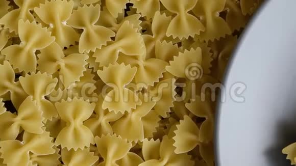 食品背景灰色盘子上的干法法勒意大利面全生料视频的预览图