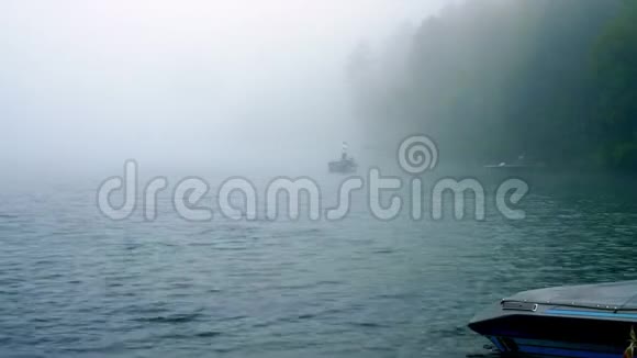 清晨船上的渔夫正在美丽的雾蒙蒙的达湖上钓鱼视频的预览图