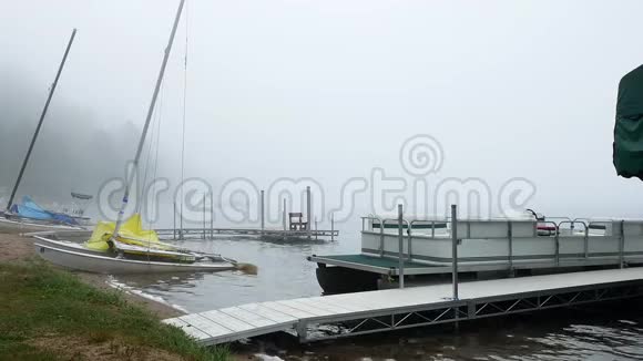 在雾蒙蒙的早晨明尼苏达州的一个湖滩有船坞浮舟和游艇等着欣赏旅游胜地视频的预览图