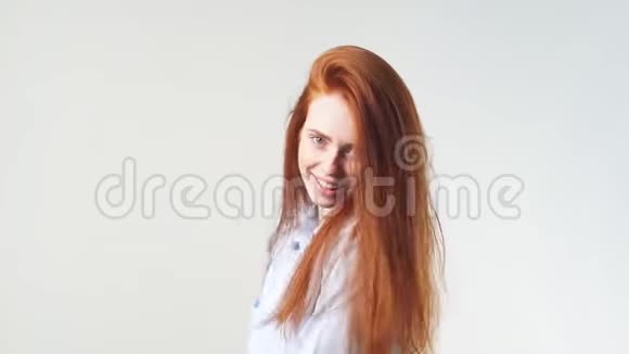 美丽的女孩有着奢华的红色头发摆着姿势在镜头前微笑视频的预览图