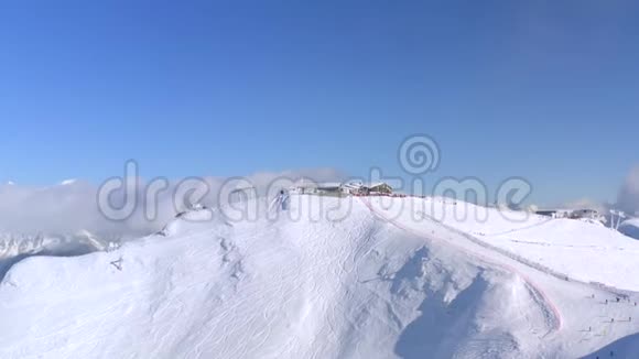 从冬季山地度假胜地上方的空中景观人们在冬季滑雪场的雪坡上滑雪和滑雪板滑雪场视频的预览图