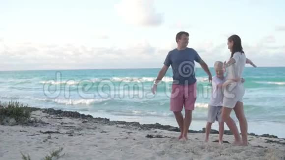 一家人在大海的背景下拥抱和亲吻视频的预览图