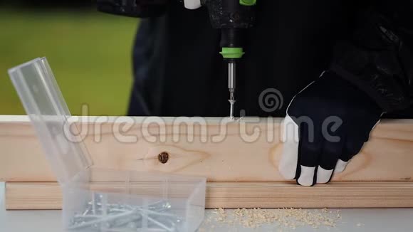 慢速胶卷显示男性用无绳螺丝刀在木板上工作的近景视频的预览图