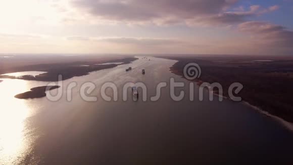 从空中射击河上漂浮的驳船在美丽夕阳的背景上视频的预览图