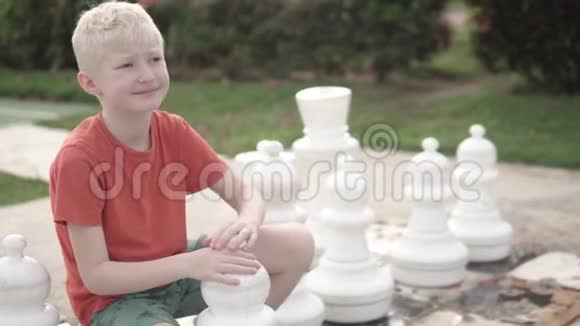 漂亮的金发男孩在旅馆里下棋视频的预览图
