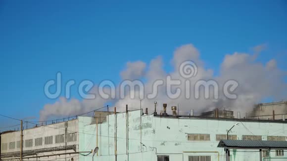 在一个工业城市里在蓝天的映衬下吸烟的烟囱视频的预览图