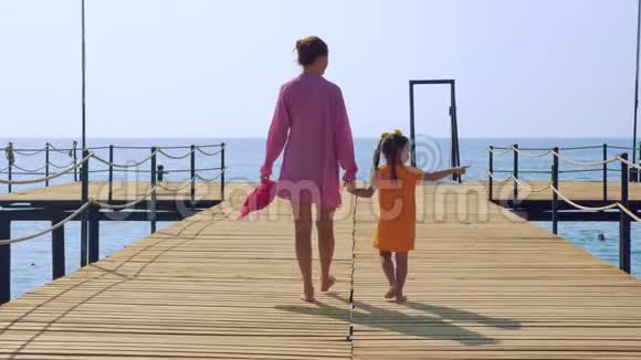 母女俩沿着海边的码头漫步欣赏大海视频的预览图