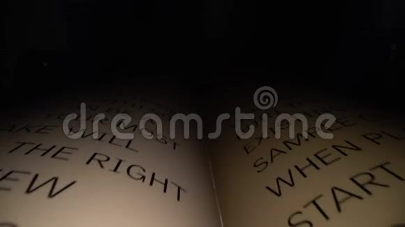 多利的镜头在书中滑动字母拉丁字母和单词在一本黑色戏剧开放的书上视频的预览图