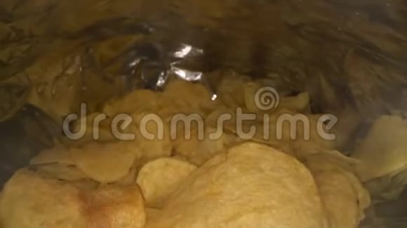 摄像机的多利镜头在薯片袋里滑动打开了一包原味美味的土豆薯片快餐和快餐视频的预览图