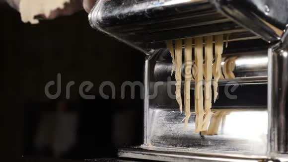 面条或意大利面制造机器从意大利面机中取出的新鲜意大利面的慢速食物片段视频的预览图